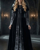 Black maxi dress with tie-neck bodice and skull-print skirt, short cape sleeves