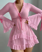 Pink sheer mesh babydoll chemise with ruffled trim, long sleeves, and ribbon tie front