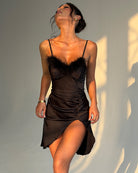 Black satin slip dress with feather trim bust, ruched waist and high thigh slit