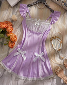Lavender satin babydoll mini dress with ruffled shoulders, ribbon bows, and lace hem