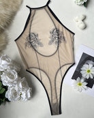 Sheer mesh rose print bodysuit with black trim and high-cut leg