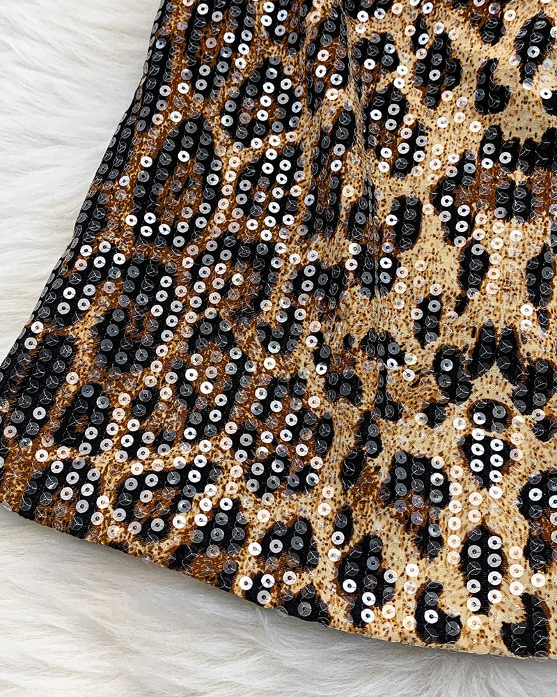 Leopard sequin pattern close-up with black, tan, and gold sparkle
