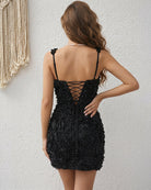 Black mini dress back view with spaghetti straps and crisscross lace-up corset opening.