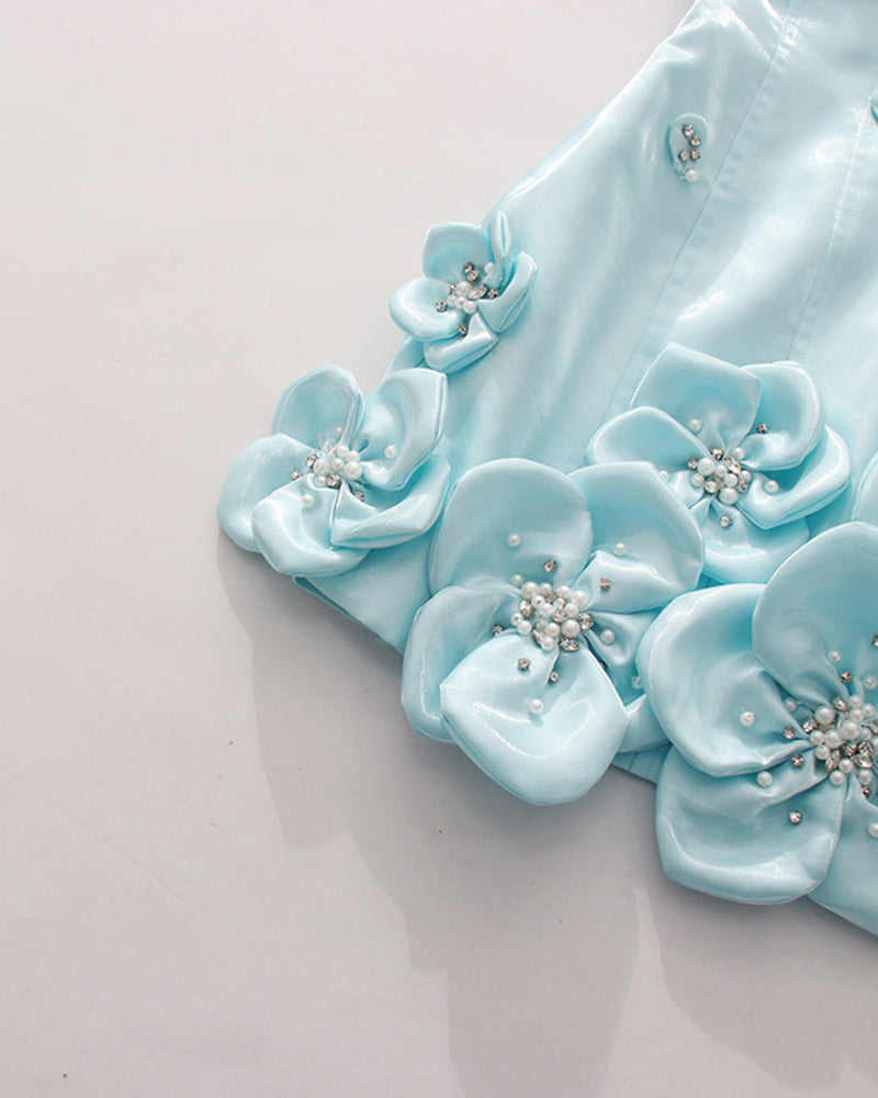 Close-up of sky blue 3D floral appliques with rhinestone centers on corset dress