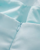 Sky blue corset bodice detail with smooth fabric seam and small button closure