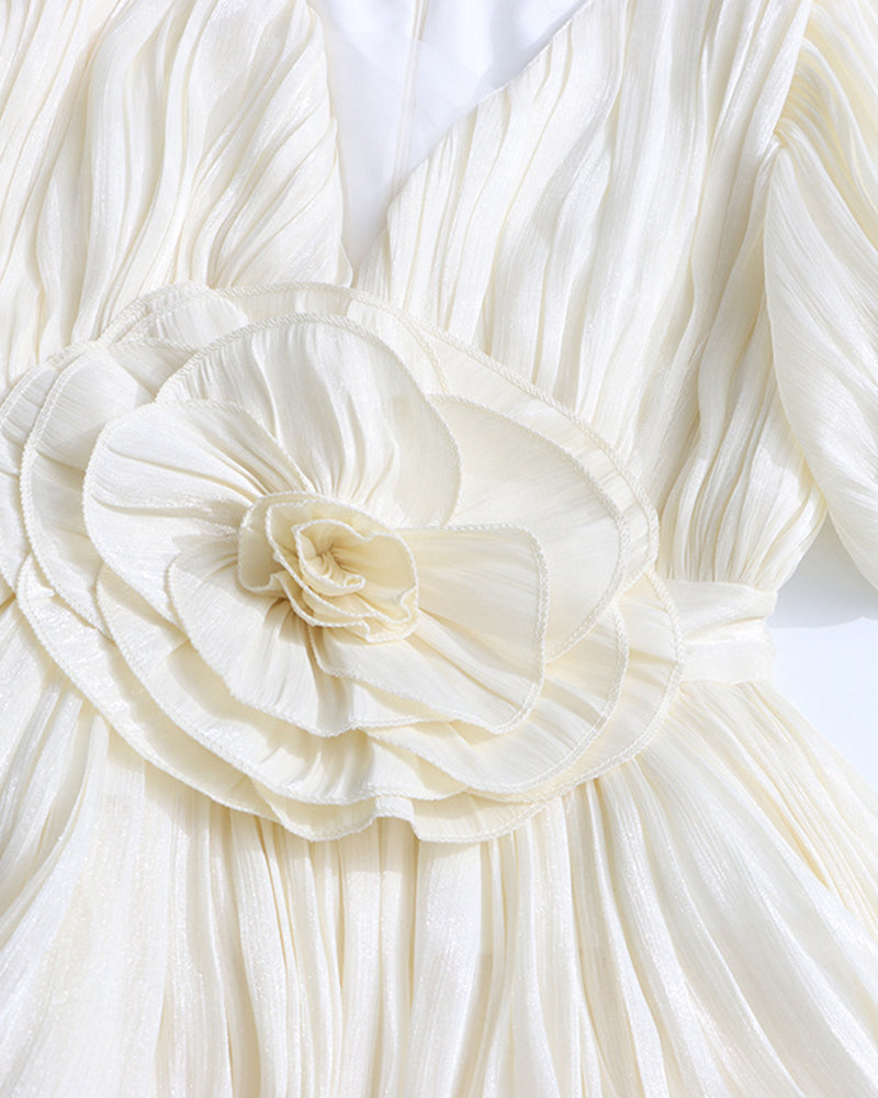 Close-up: champagne floral waist rosette on a pleated mini dress with puff sleeves