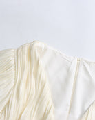 Champagne puff sleeve and pleated bodice detail on a mini dress