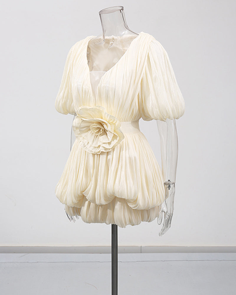 Champagne pleated mini dress with deep V neckline, puff sleeves, and waist rosette