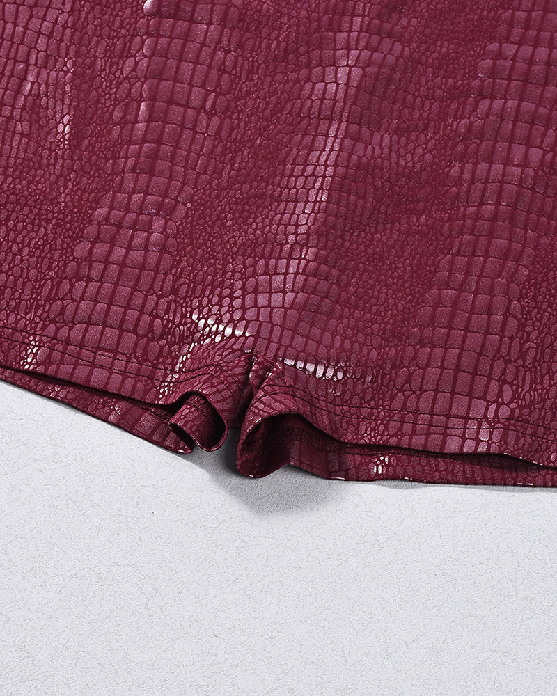 Burgundy croc-embossed faux leather romper bodysuit, close-up of shorts hem