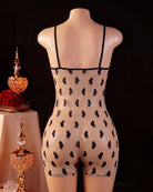 Back view of black romper on mannequin with heart-pattern mesh panel and thin straps