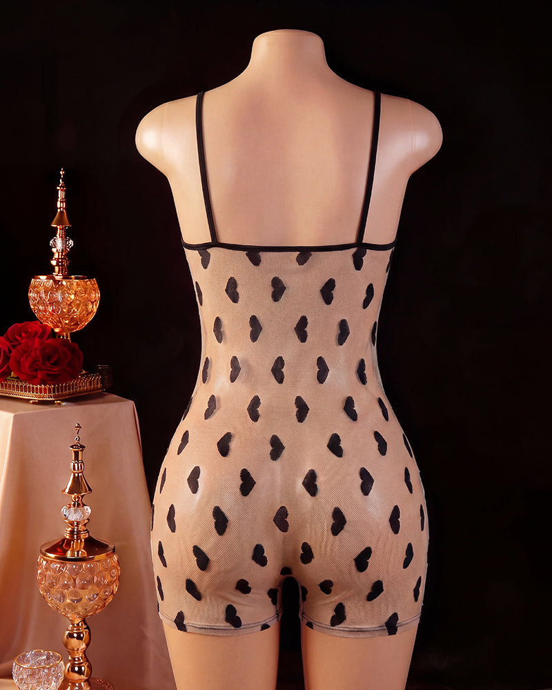 Back view of black romper on mannequin with heart-pattern mesh panel and thin straps
