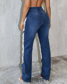 Light blue denim jeans with ripped seams and frayed side hem
