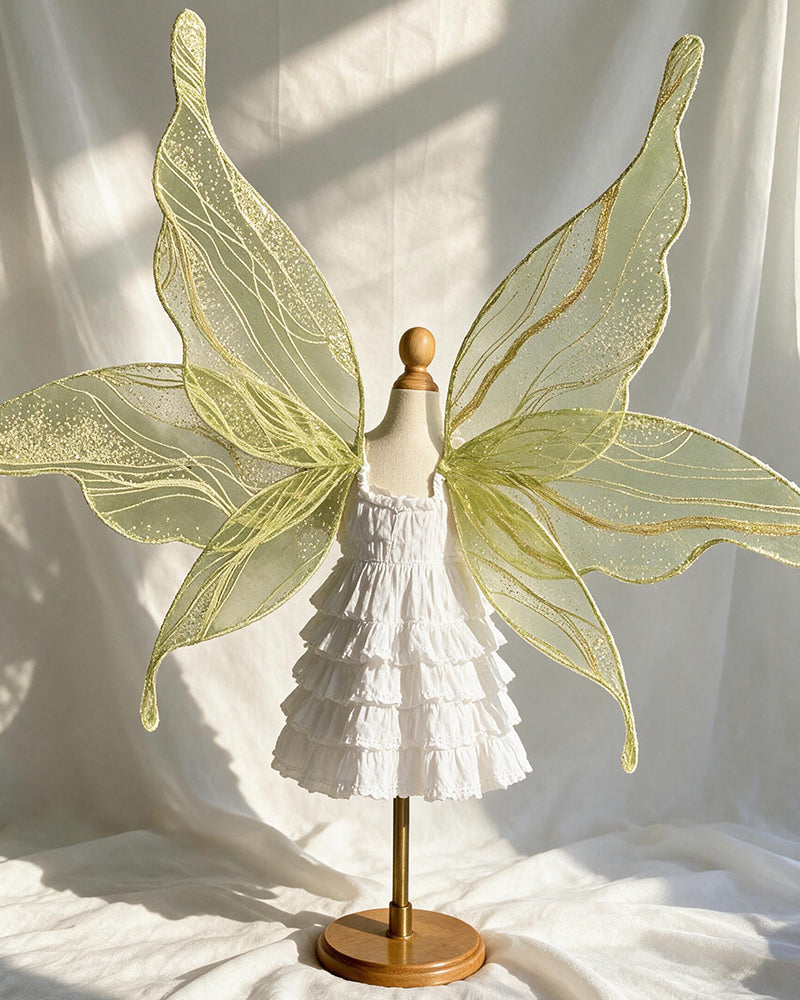 Yellow-green glitter fairy wings with leaf-shaped design over a white ruffle costume