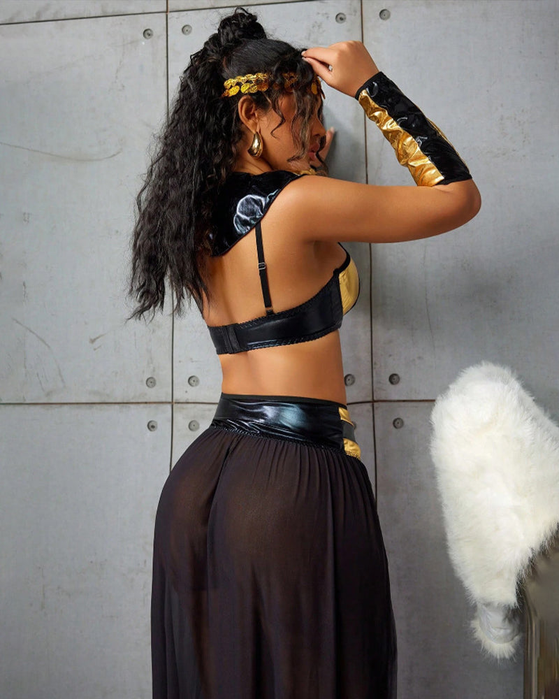 Back of black maxi skirt with metallic gold arm gloves and gold-trimmed bra top