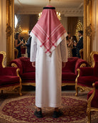 White robe with red check headscarf draped over back, black shoes, back view