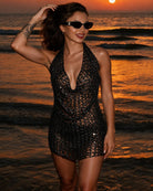 Black sequin halter fringe top on model with deep V-neck and short hem