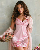 Pink satin slip chemise with floral embroidery, lace trim, and tie-back straps