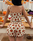 Back view: white crop cami and shorts pajama set with pumpkin and ghost print, ruffled hem