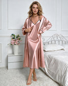 Pink satin V-neck slip dress with thin straps and open-front robe, standing