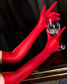 Red oil-shiny sheer opera gloves with long fitted sleeves and subtle seam detail