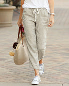 Grey drawstring elastic-waist pants, tapered ankle-length with white rope tie