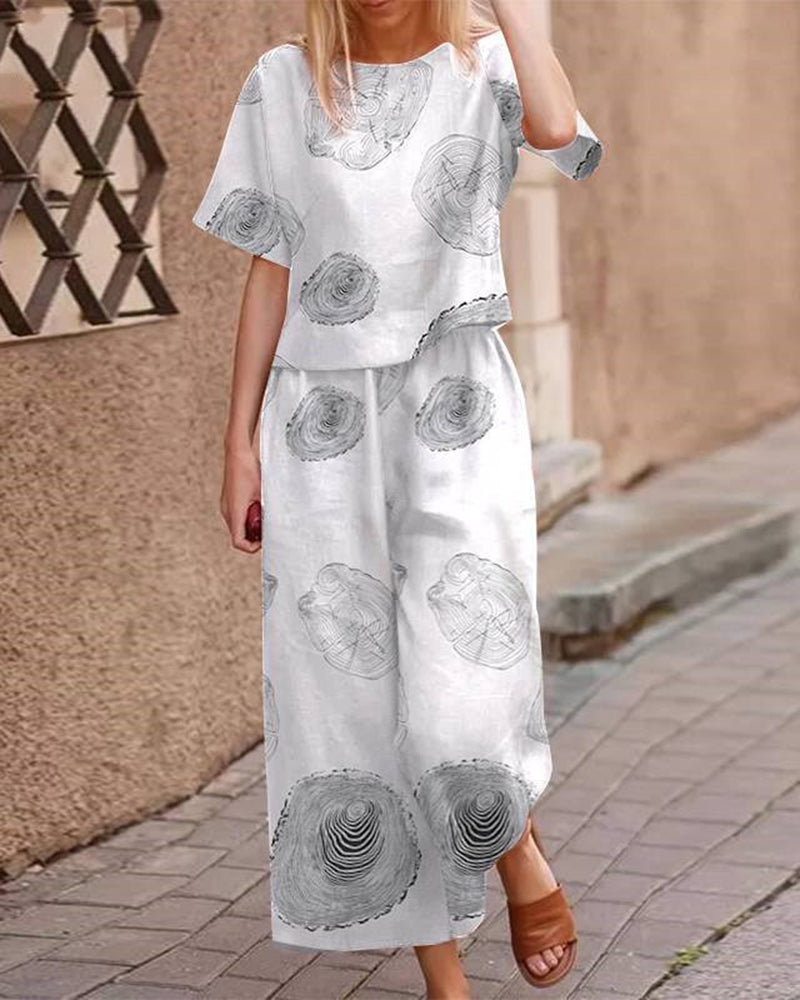 White two-piece set with short-sleeve top and matching wide-leg pants, gray circles