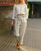 White two-piece pants set with long-sleeve blouse and drawstring waist pants